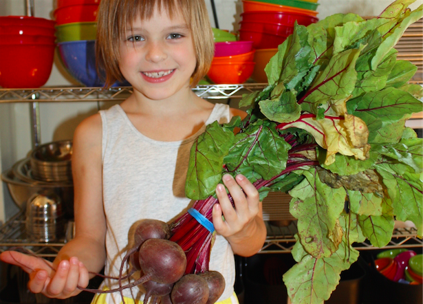 Taste-Buds-Kitchen-Beets a little girl sitting at a table with a plate of food