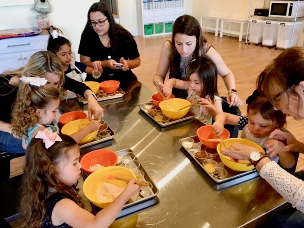 a group of people sitting at a table with food