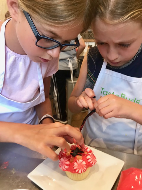 a woman sitting on a cutting board with a cake