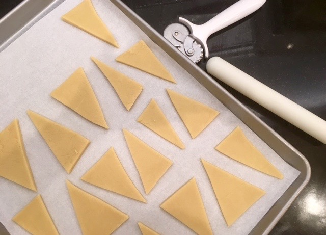 place dough triangles onto wax paper on sheet pan