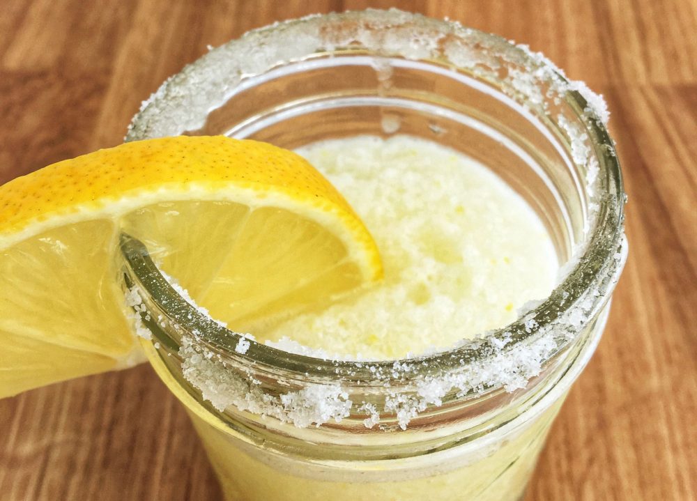 fresh squeezed juice with sugar and a lemon wedge on the rim