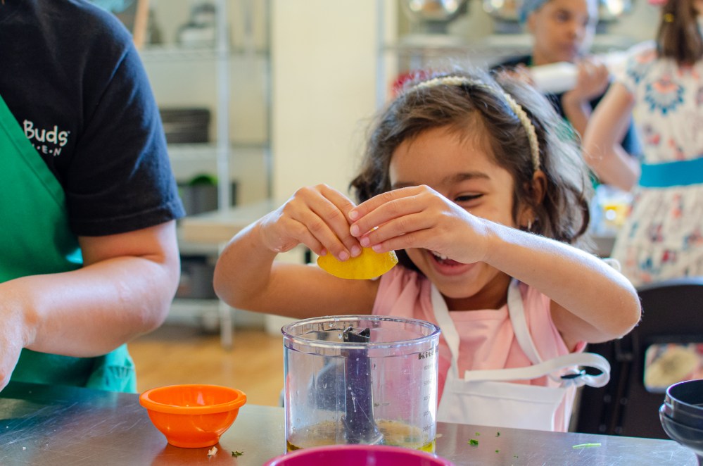 kid squeezing a lemon into a mixer