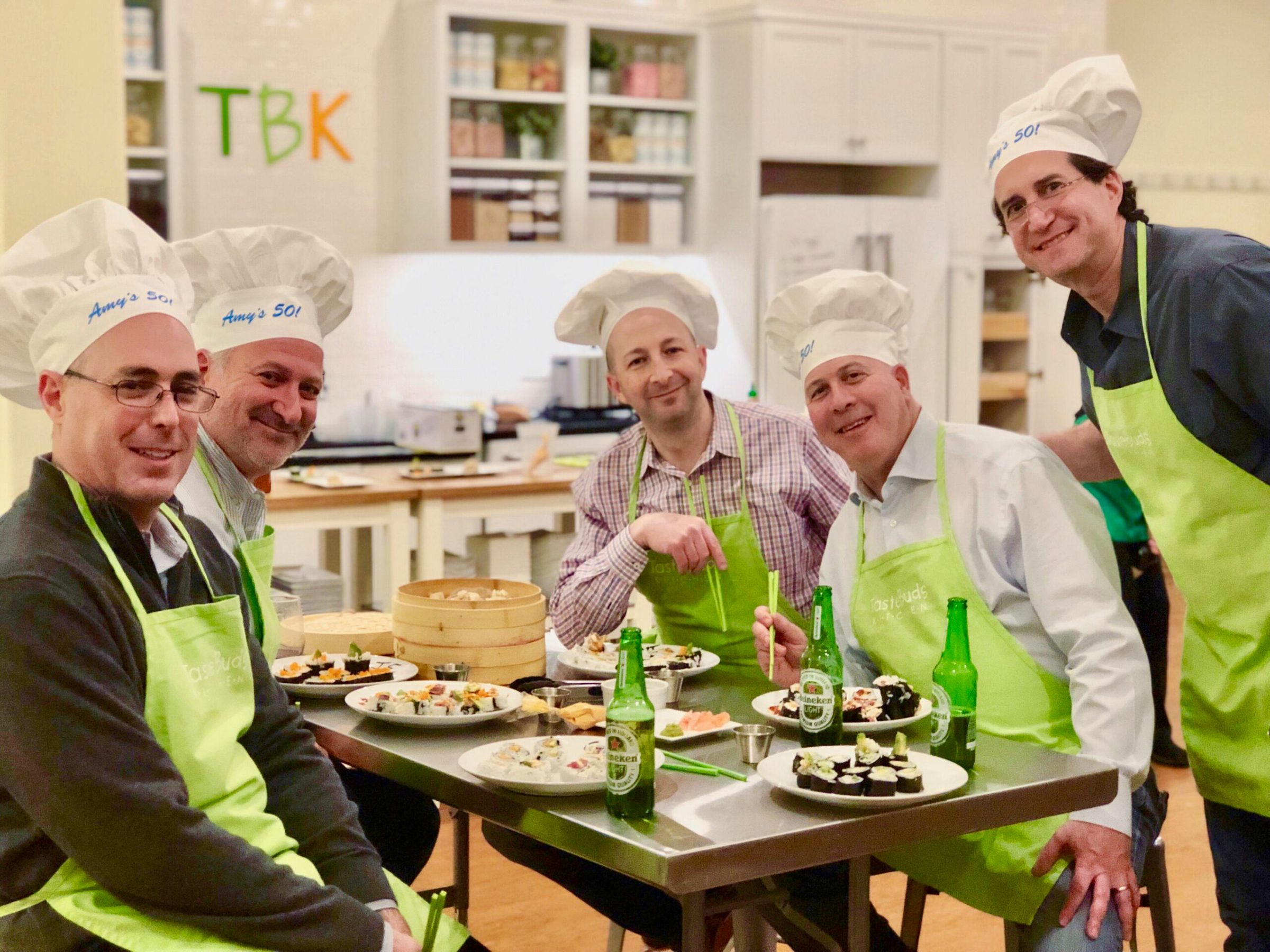 a group of men smiling after a sushi making class