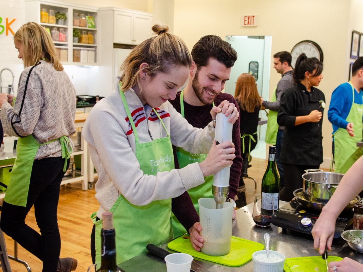 a couple using a food mixer at a byob cooking event