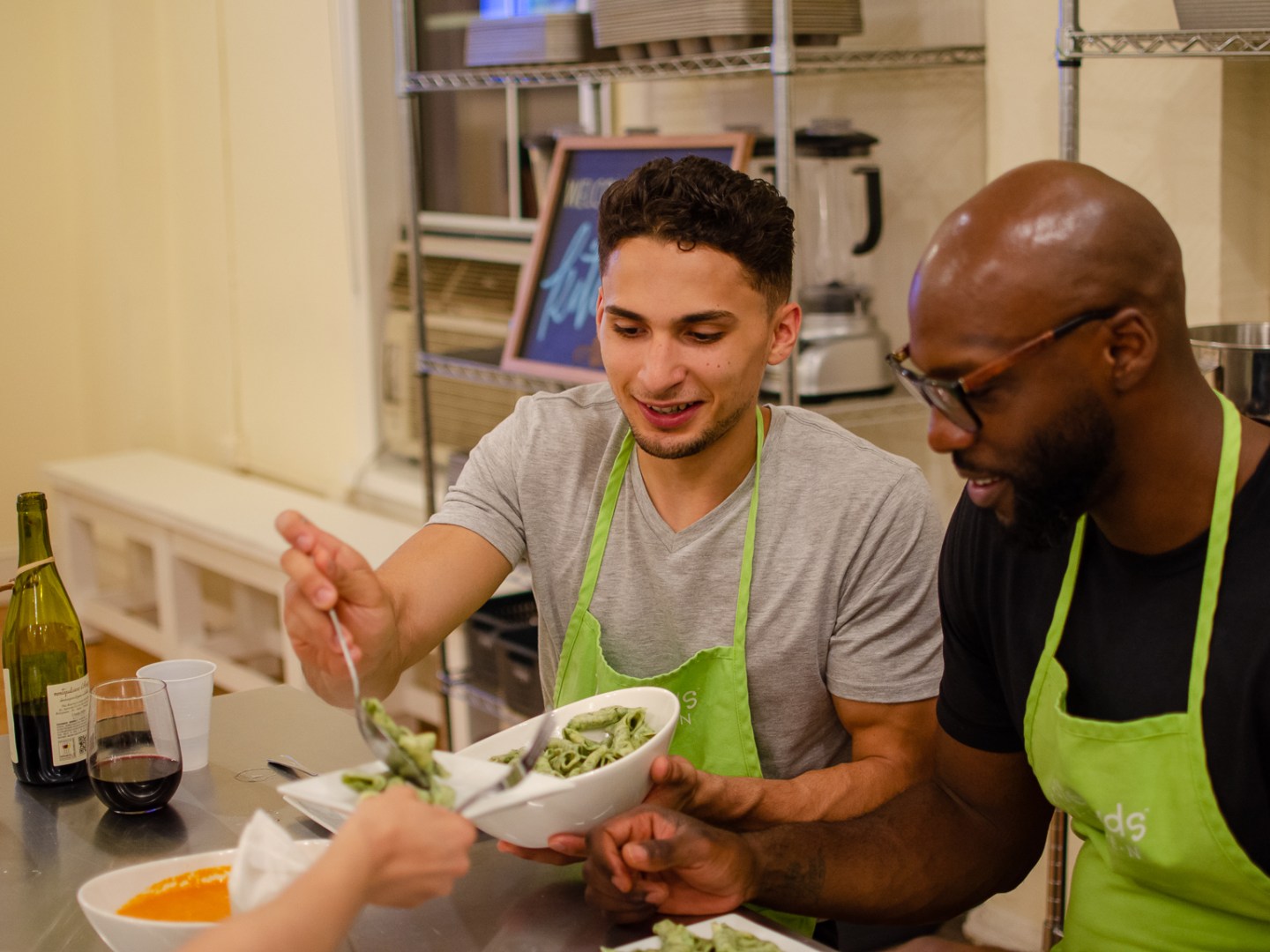 two men helping themselves to homemade pesto pasta