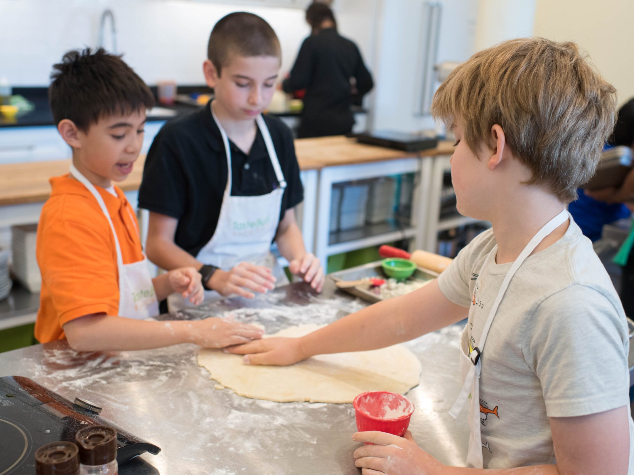 a group of boys rolling dough
