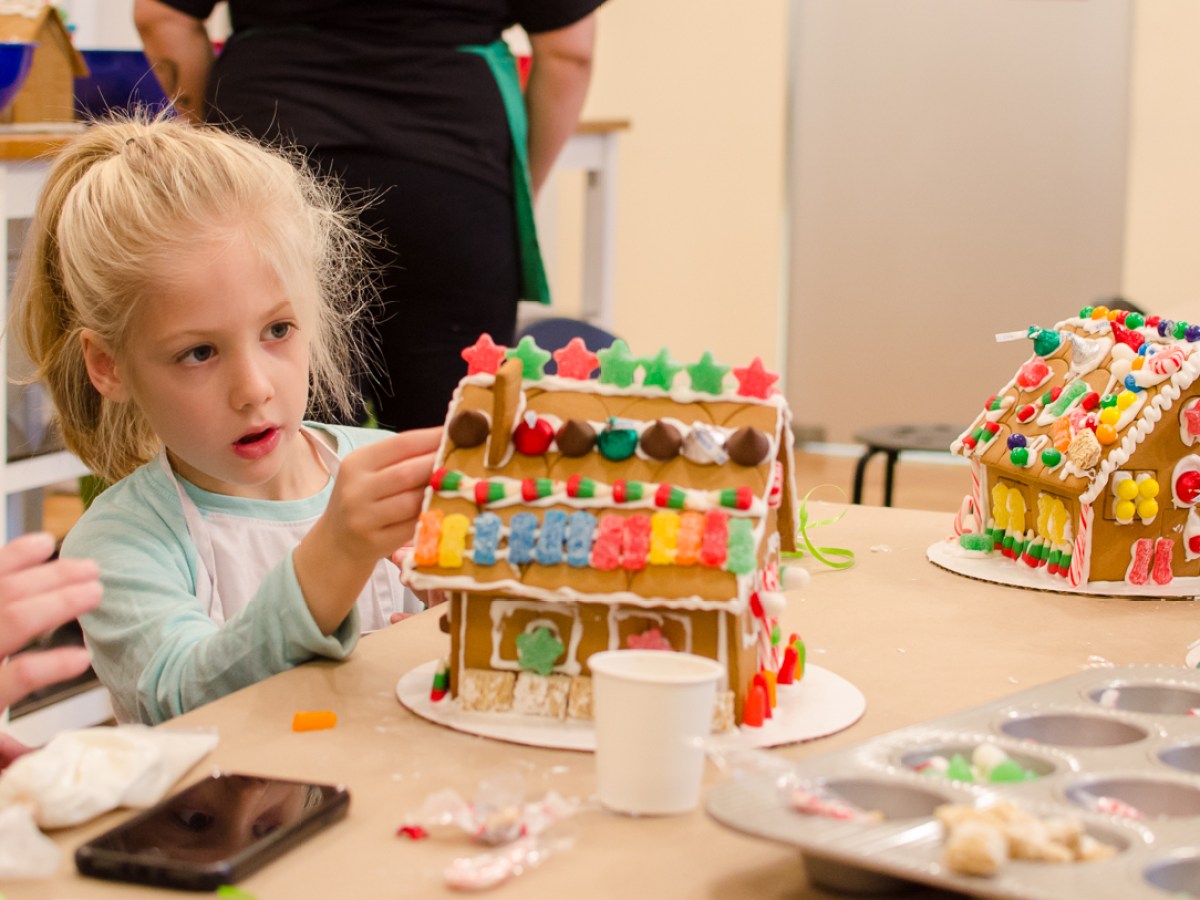 a little girl sitting at a table with a birthday cake