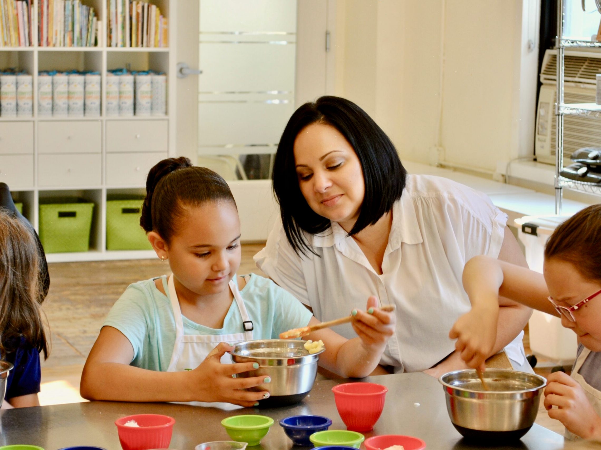 a mother and daughter mixing ingredients
