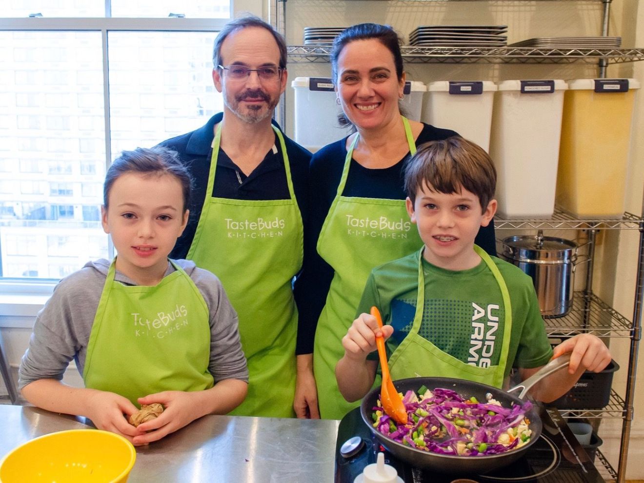 a family cooking vegetables in a pan