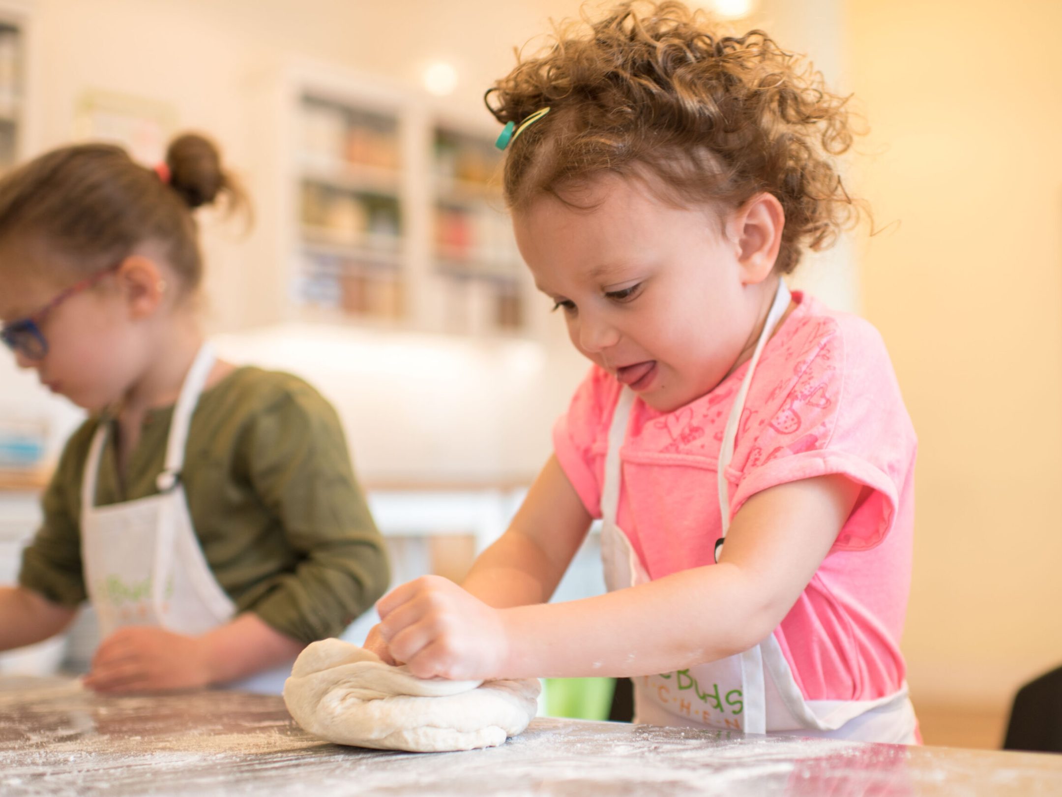 two young girls folding dough