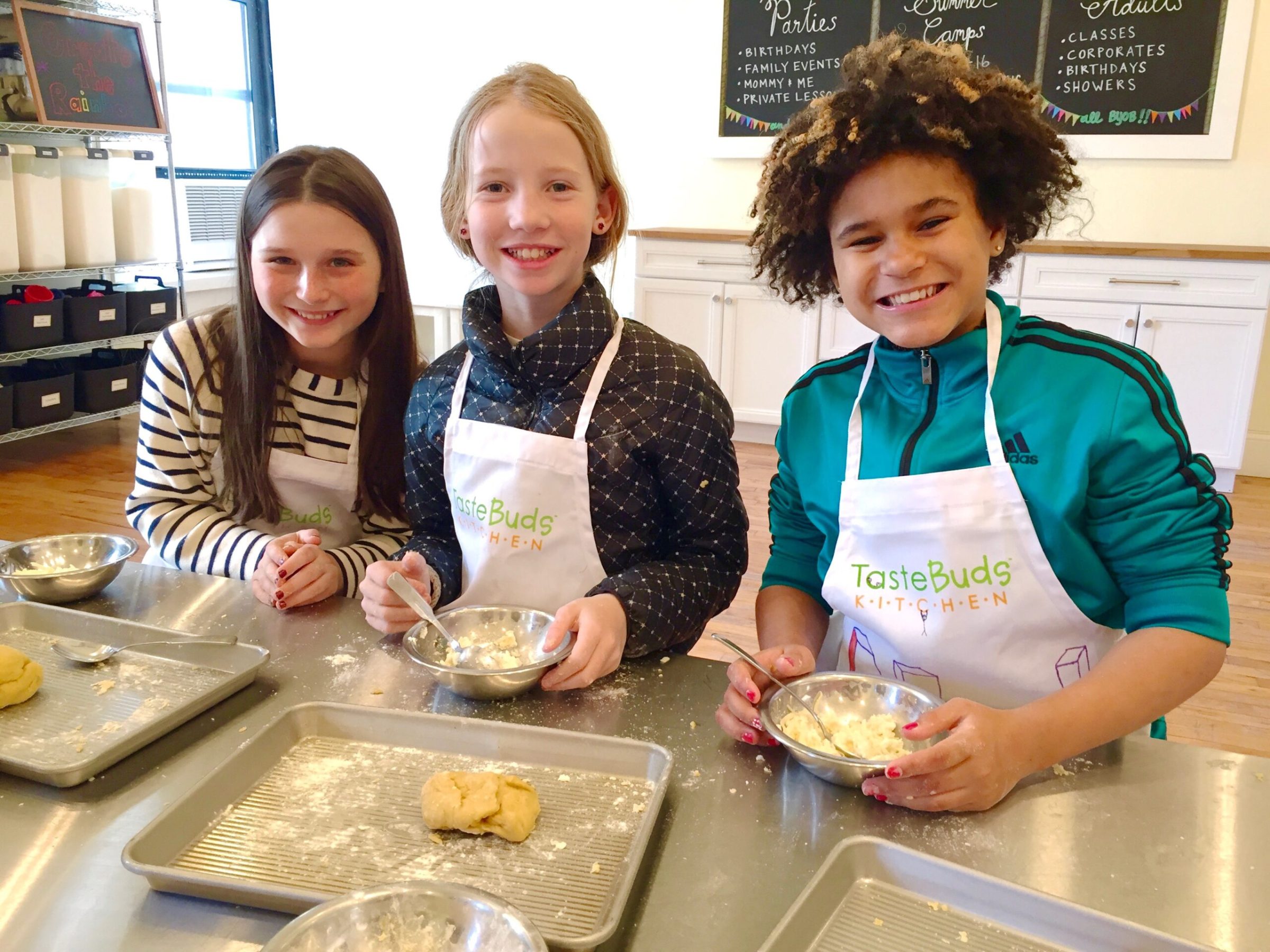 a group of kids sitting at a table with food