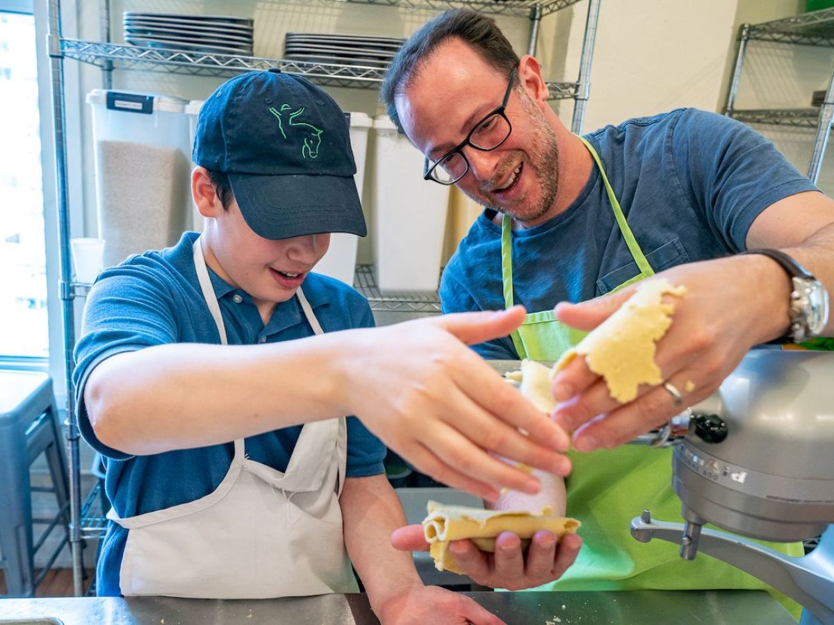 a dad and son making pasta
