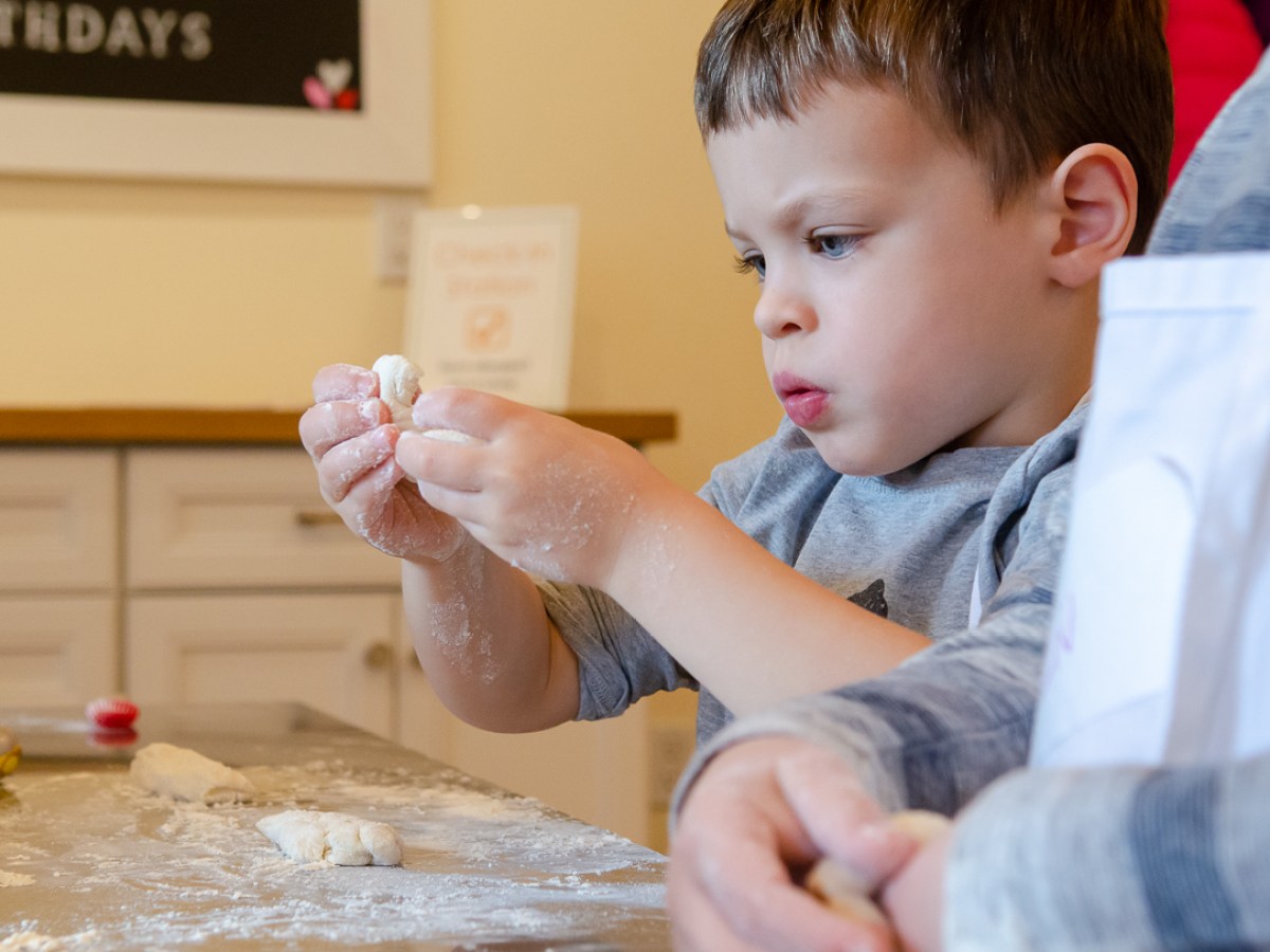 a young boy playing with garlic dough