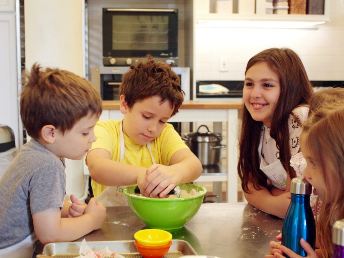 a group of kids in front of a mixing bowl