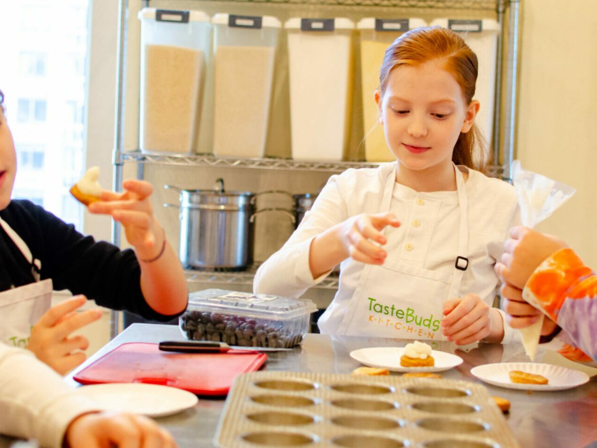 a group of kids icing cookies