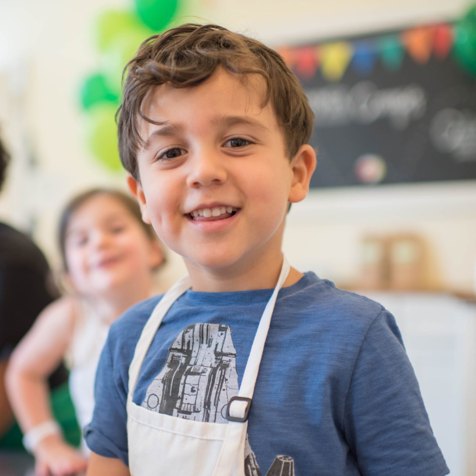 Boy Birthday2 smiling young boy in blue shirt with white apron on