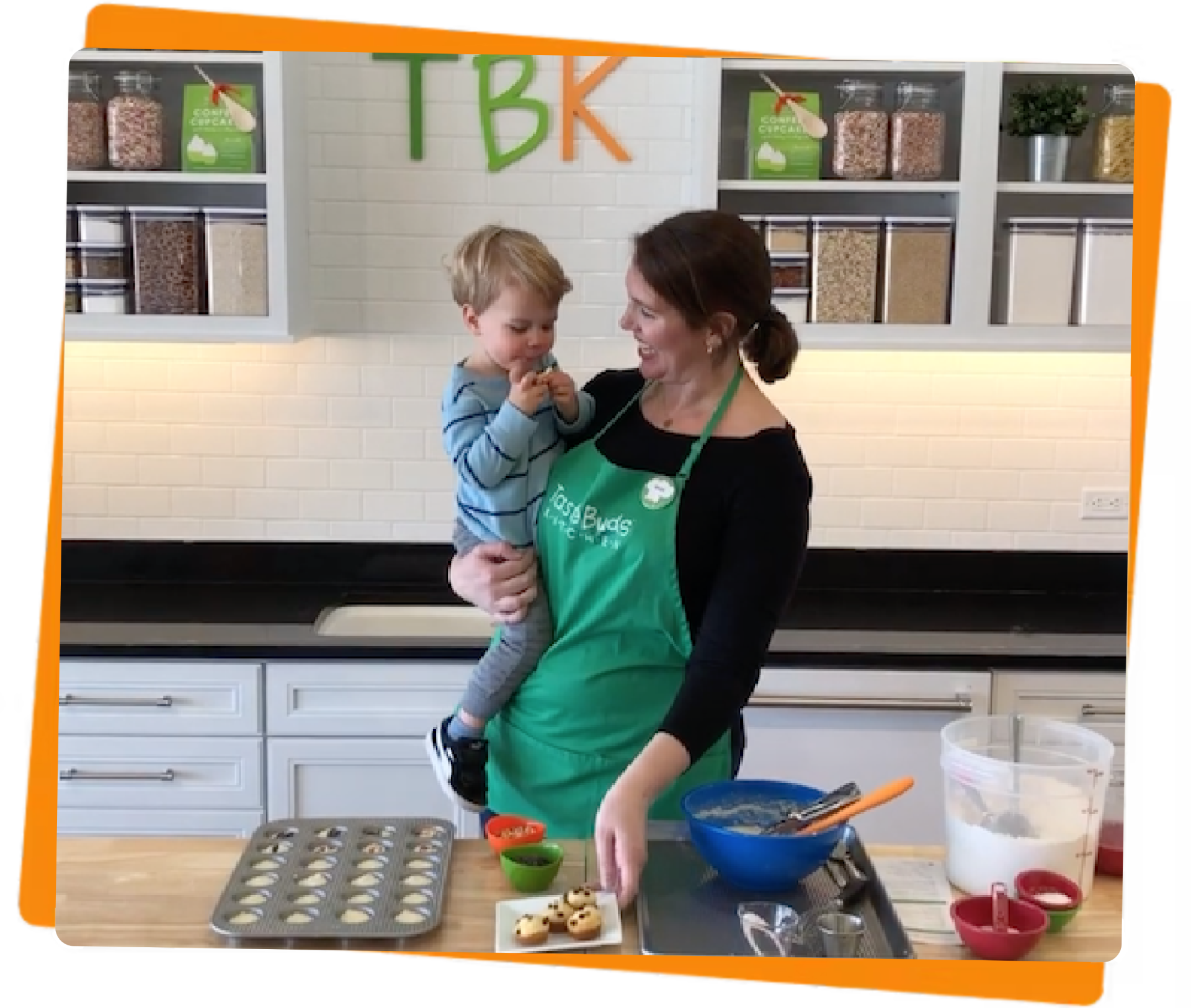 Women and son in kitchen making muffins