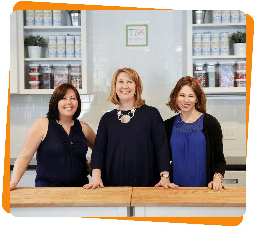 Untitled design (25) three women posing for the camera in the kitchen